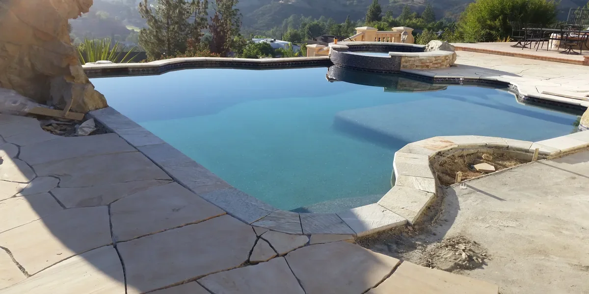 Modern geometric gunite pool with white glass tile and concrete deck in Beverly Hills