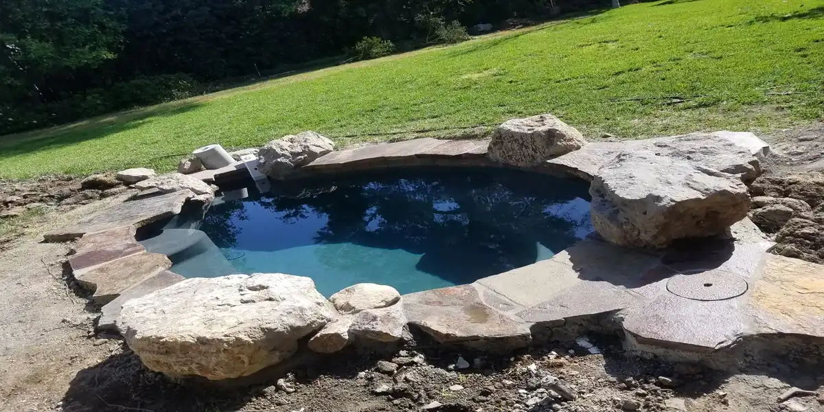 Resort-style pool with rock waterfall and flagstone deck in Pacific Palisades